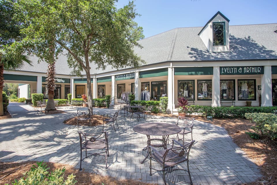 A building with a sign reading "Evelyn & Arthur" and outdoor seating area with tables and chairs.