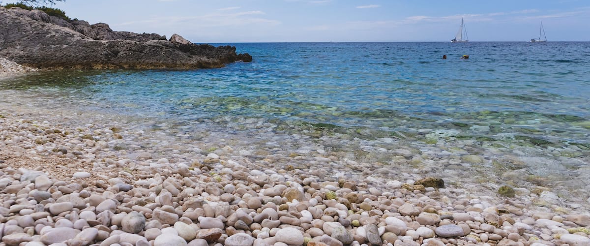 Fascinating blue Adriatic sea splashing white pebble "Mekicevica" beach on the Hvar island, popular nautical tourist destination in Croatia