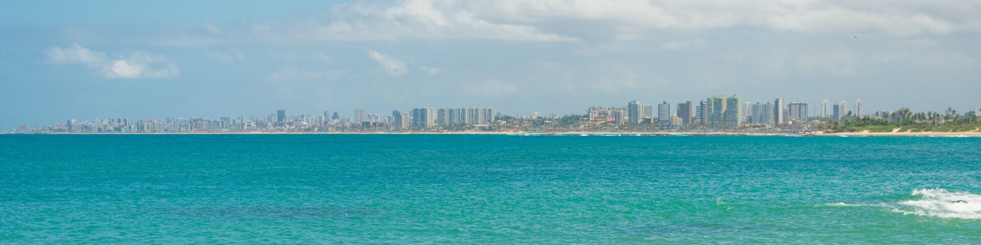 A view of the beach in Itapua, Salvador's cityscape in the background - Bahia, Brazil