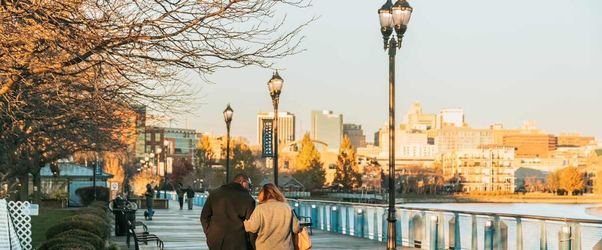 Wilmington Riverwalk featuring a sunset as well as a couple