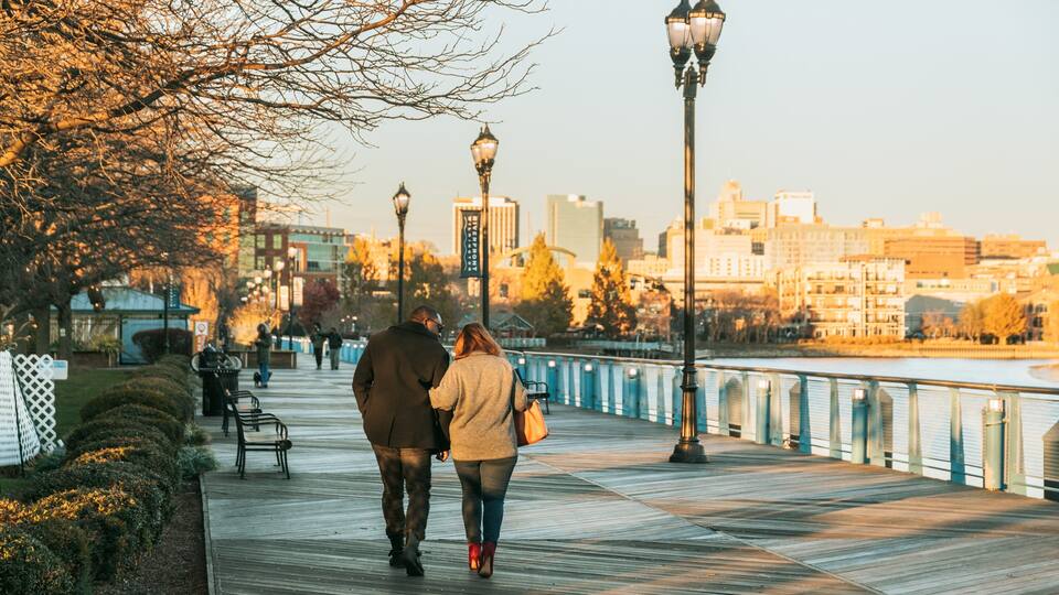 Wilmington Riverwalk featuring a sunset as well as a couple