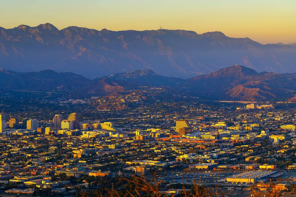 A cityscape with a mountain range in the background.