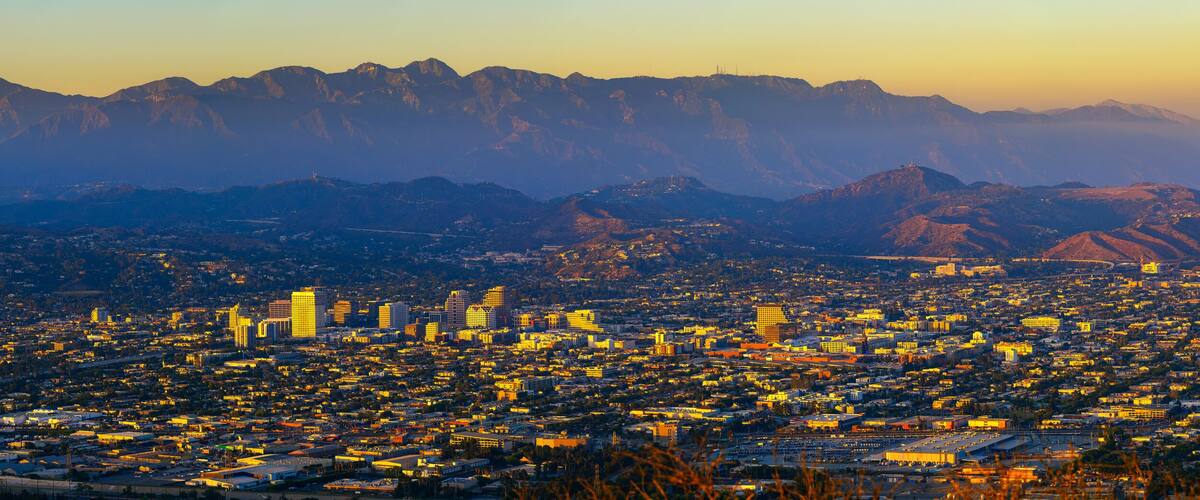 A cityscape with a mountain range in the background.