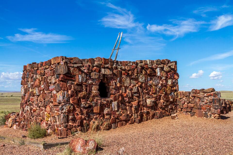 Edifici de pedra amb una escala, en un paisatge sec.