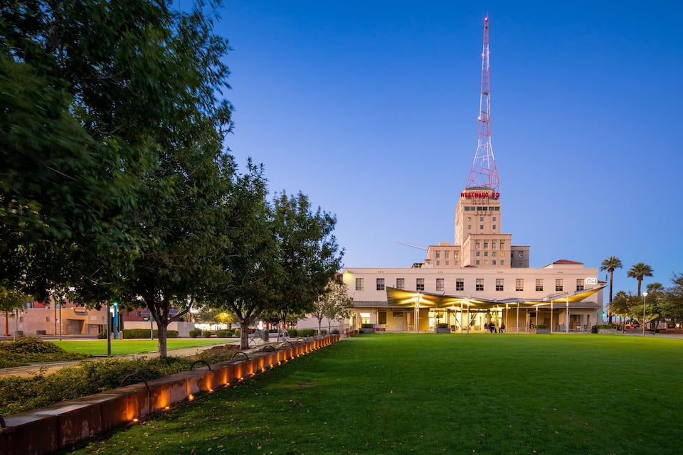 A large building with a tall tower, surrounded by a well-maintained lawn and trees.