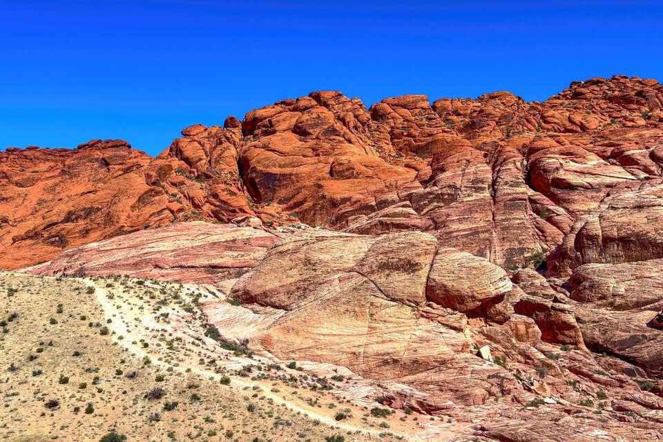 A rugged red rock landscape with a clear blue sky.