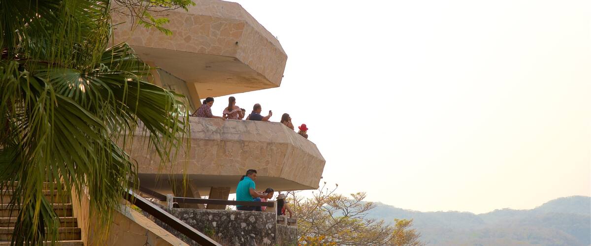 A stone staircase leading up to a viewing platform with people sitting and taking photos.