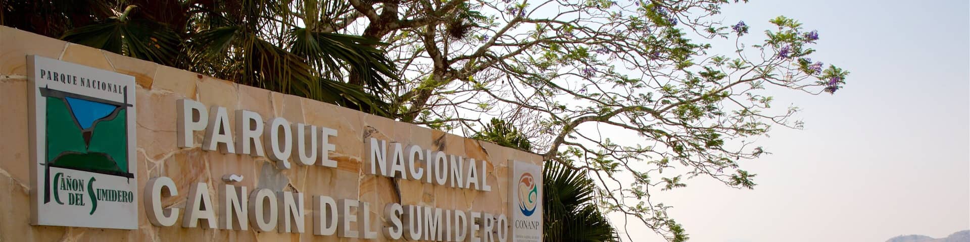A stone wall with signs for Parque Nacional and Canon del Sumidero.