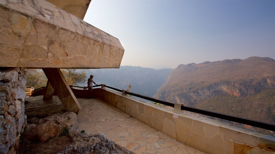 A stone pathway leading to a viewpoint overlooking a mountainous landscape.