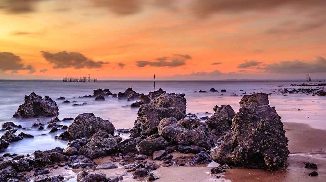 sunrise on deserted green tip beach with waves of the sea hitting the rocks in Panaquatira neighborhood, city of São José do Ribamar, Maranhão state, Brazil