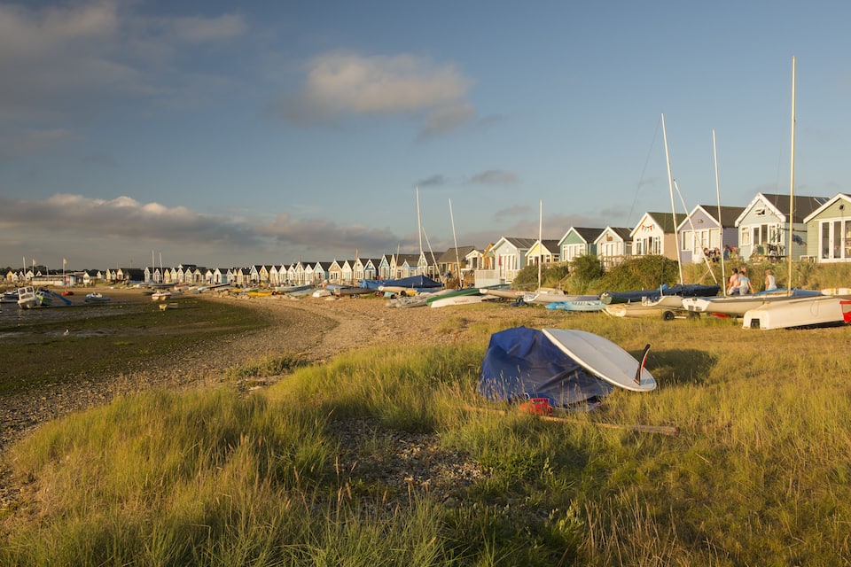 Una playa con casas adosadas y barcos.