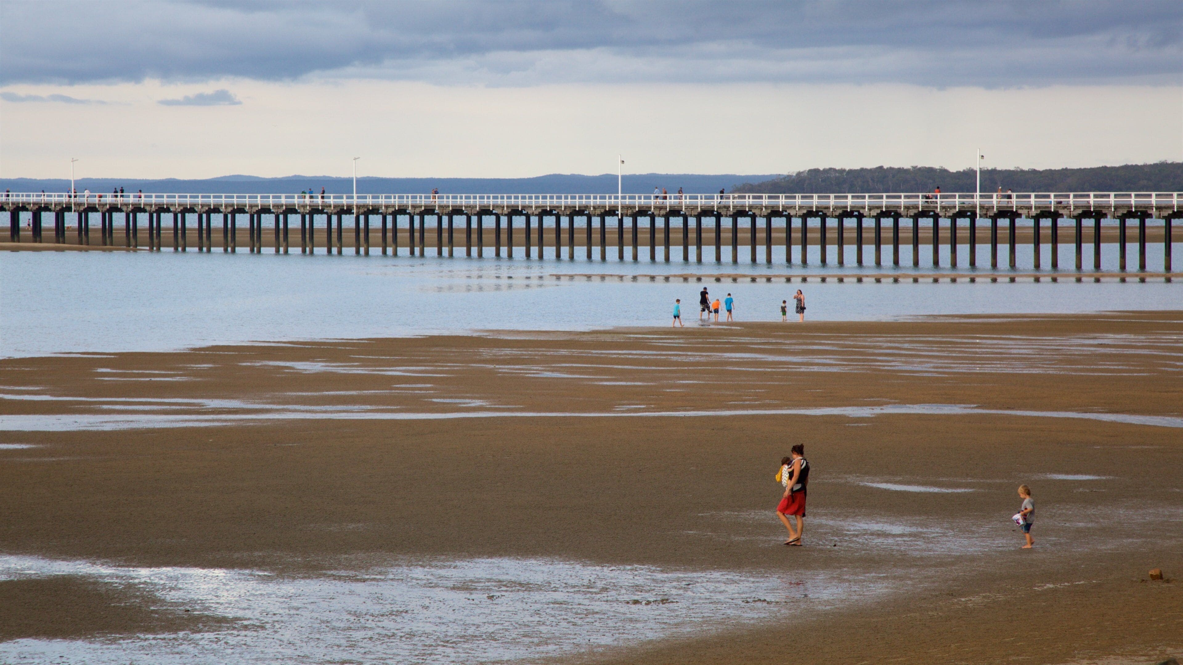 A beach with a pier extending into the water.