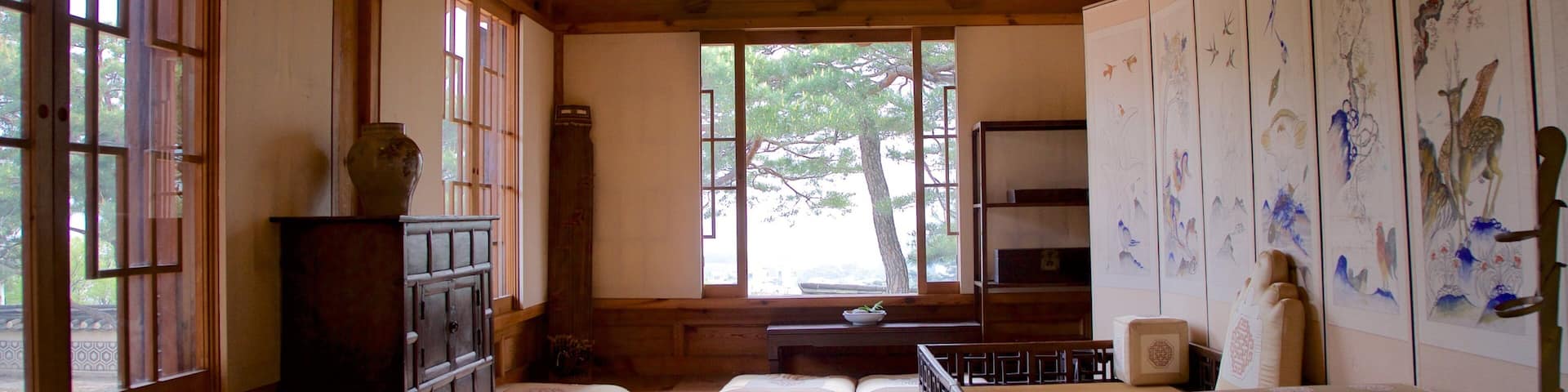 Una habitación japonesa tradicional con esteras de tatami, mobiliario de madera y arte caligráfico.
