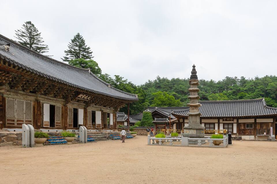 Un ensemble de temples coréens traditionnels, composé de bâtiments en bois et d’une pagode en pierre.
