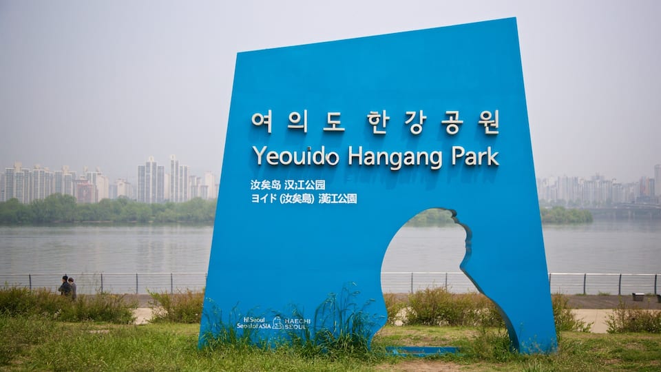 Yeouido Hangang Park showing a river or creek, a park and signage