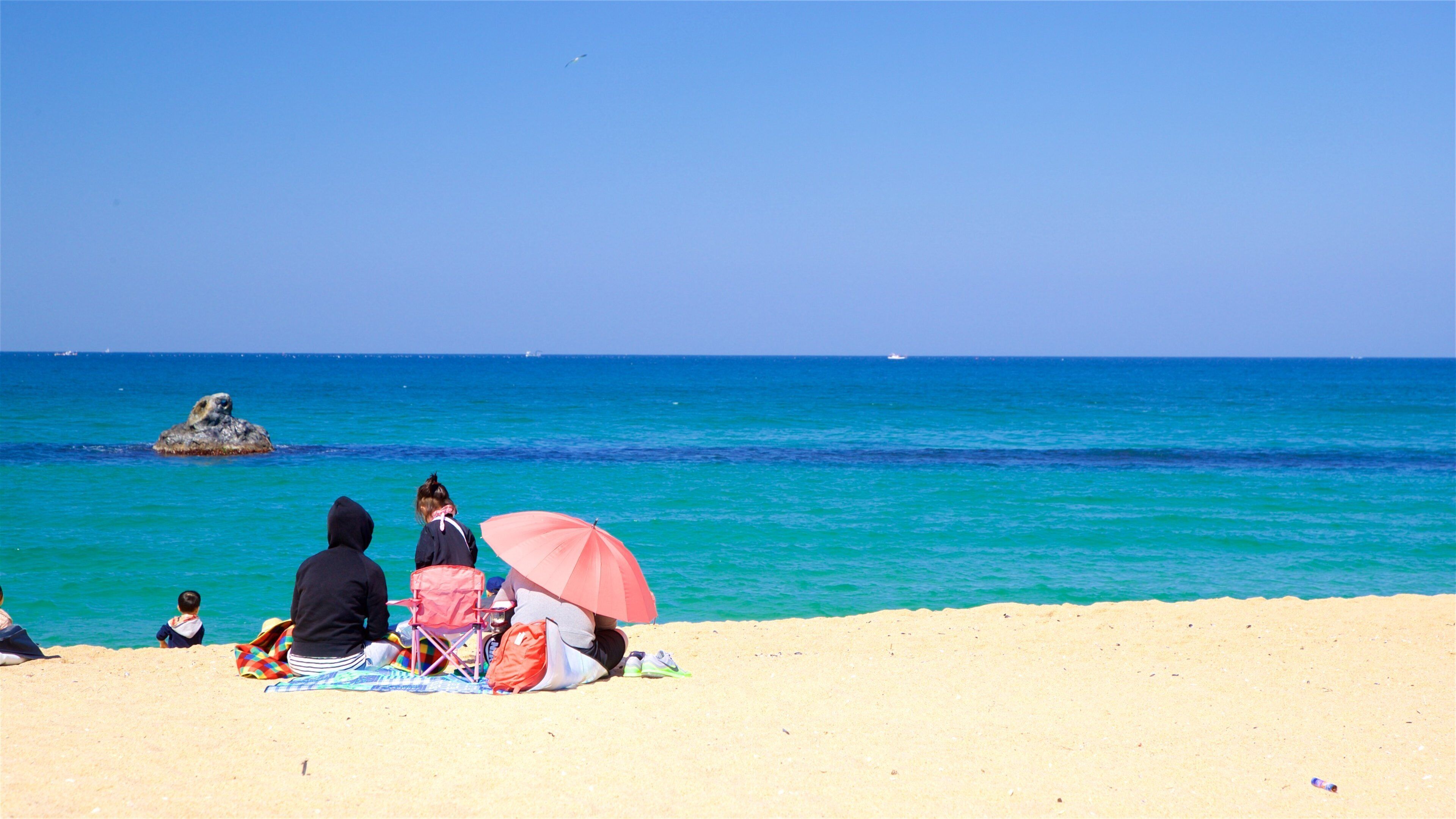 Anmok Beach which includes general coastal views and a sandy beach as well as a family