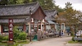 A traditional Korean market with wooden buildings and a signboard.