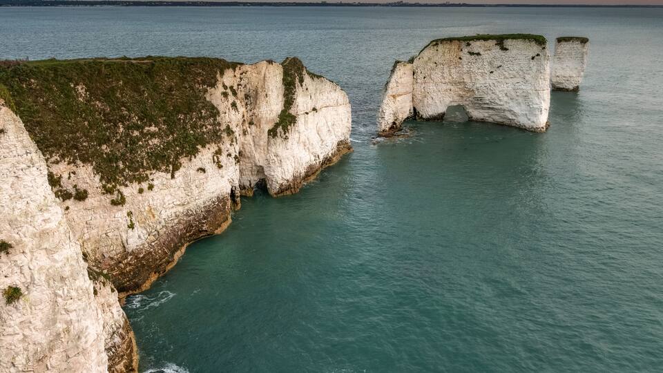 White cliffs, a body of water, and a grassy foreground.