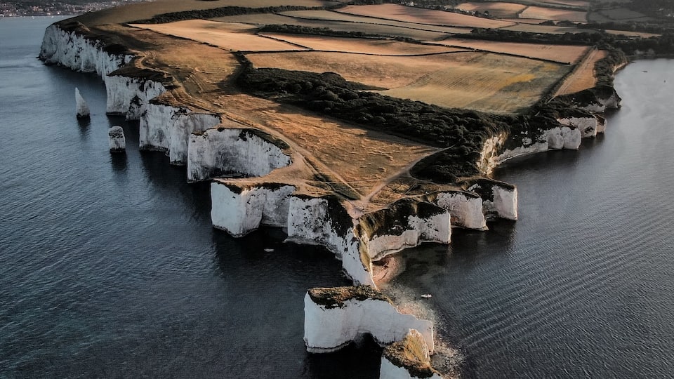 A coastal landscape with white cliffs and a river.