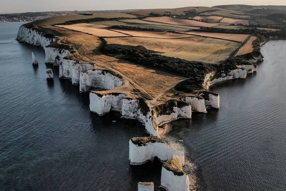 A coastal landscape with white cliffs and a river.