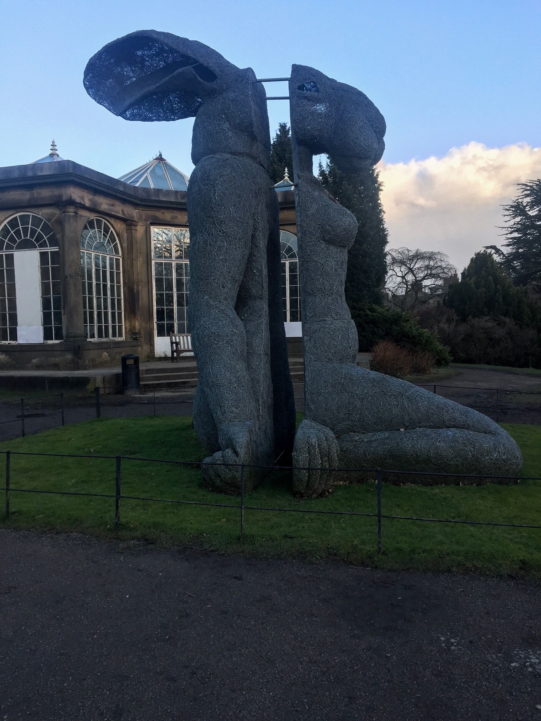 A sculpture of two figures in a garden.