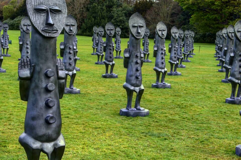 A field of abstract sculptures with human-like figures.