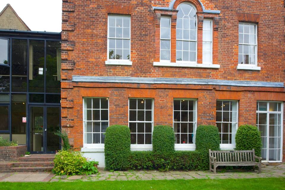 A red brick building with large windows and a white door.