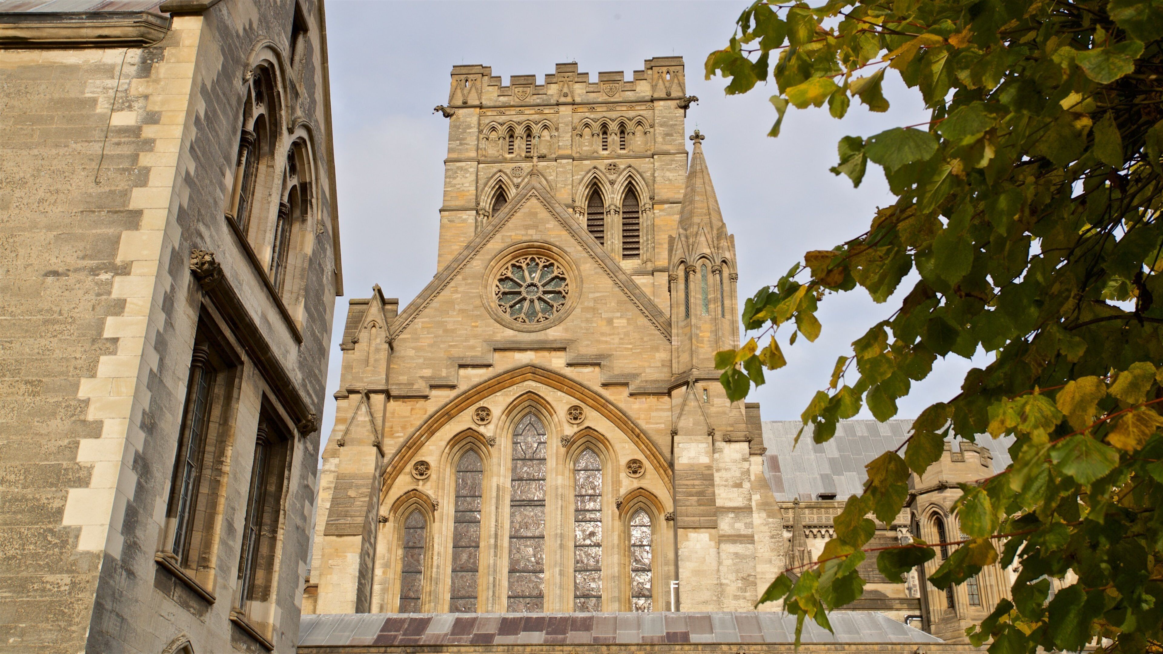 A historic church with a tall tower, large arched windows, and intricate stonework.