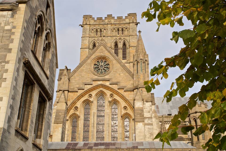 A historic church with a tall tower, large arched windows, and intricate stonework.