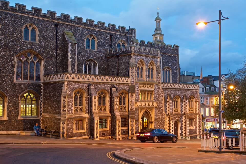 A historic stone building with arched windows and a tower.