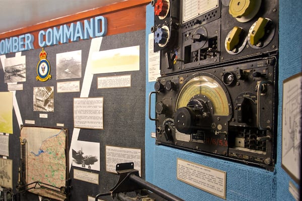 A bomber command display with historical photographs, maps, and mechanical instruments.