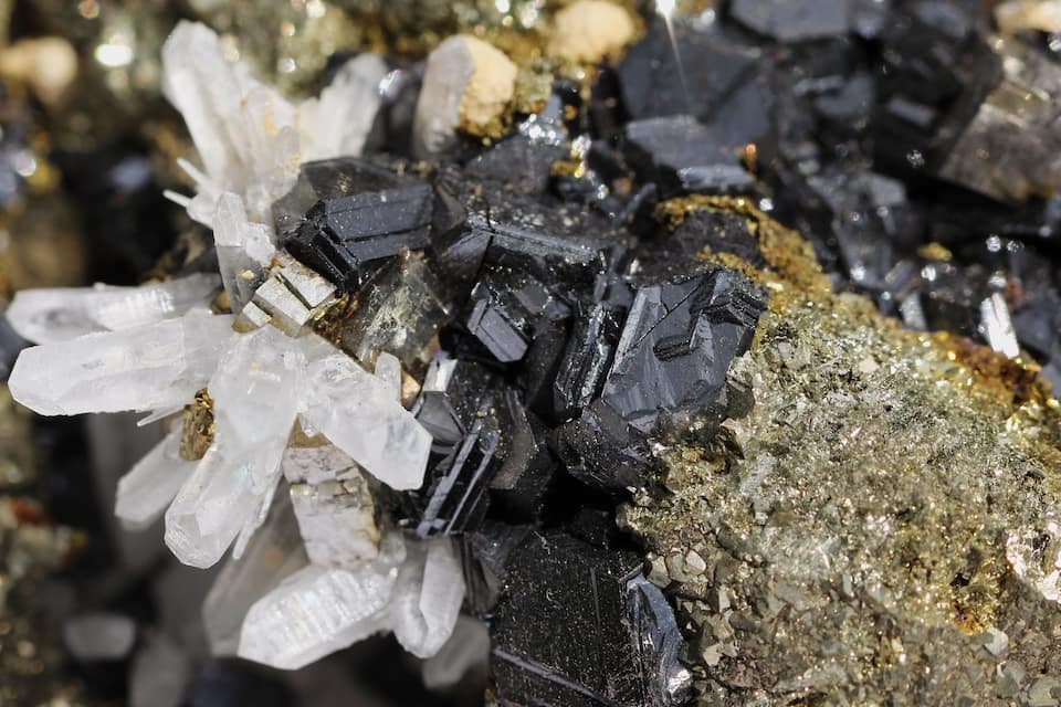A cluster of black and white crystals on a rocky surface.