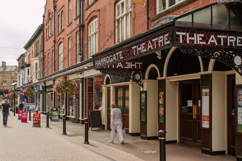 A street with a theatre named "Theatre" and a sign for "Abbott's" across the street.