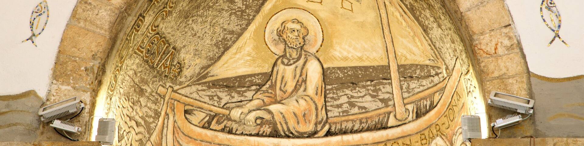 A mosaic of a saint in a boat with a cross, surrounded by ornate patterns and inscriptions.