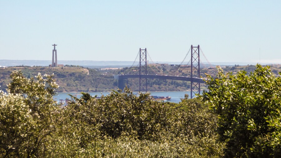 A view of Lisbon from the viewpoint of Parque Recreativo do Alto da Serafina at Monsanto Forest Park - Bridge 25th of april and Christ the King statue in the background