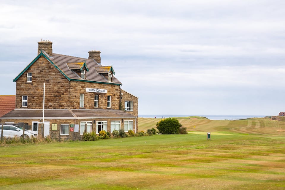 A stone building labeled "Whitby Golf Club" with a golf course in the foreground.