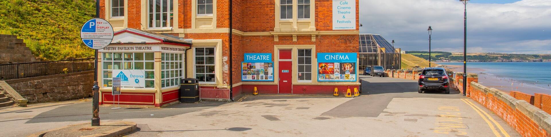 Un teatro histórico con fachada roja, una cafetería y un cine.
