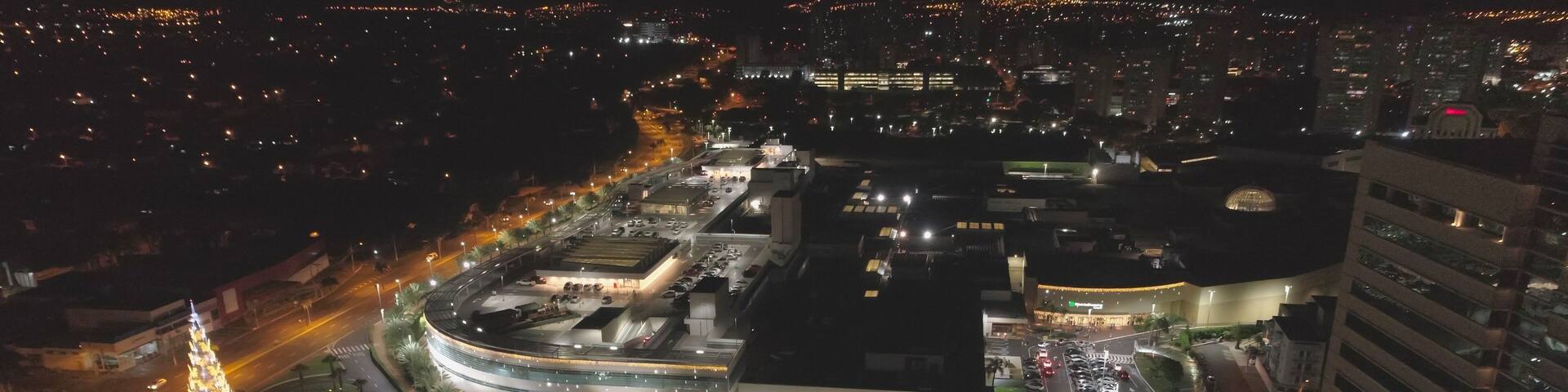Aerial view at night over Ribeirão Shopping, the largest mall in Ribeirão Preto city, Brazil. December, large Christmas tree. 4K.