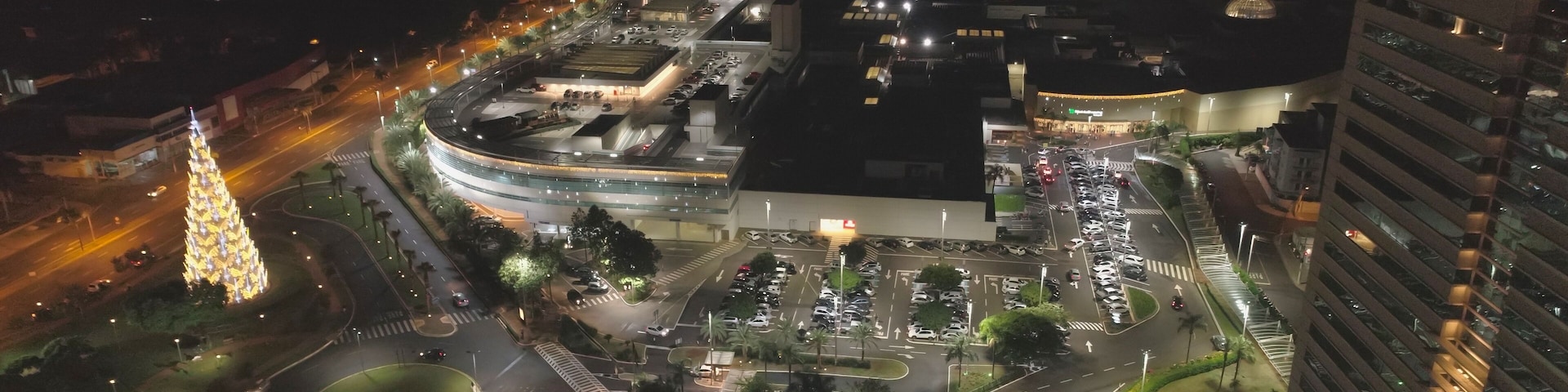 Aerial view at night over Ribeirão Shopping, the largest mall in Ribeirão Preto city, Brazil. December, large Christmas tree. 4K.