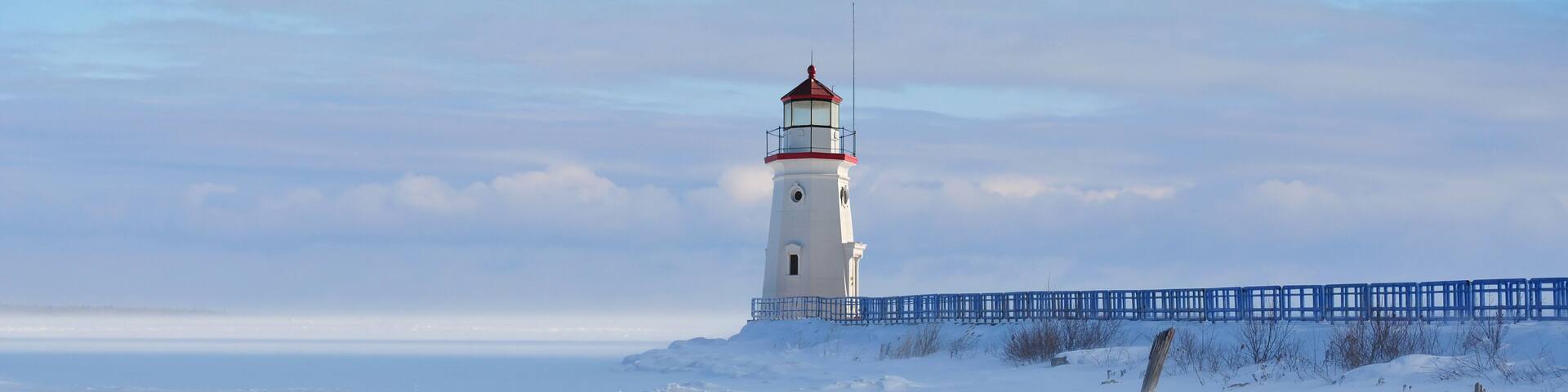 Lighthouse in a calm and desolate winter landscape.
