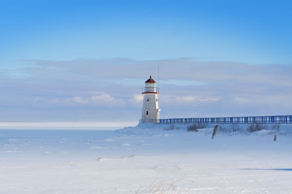 Lighthouse in a calm and desolate winter landscape.
