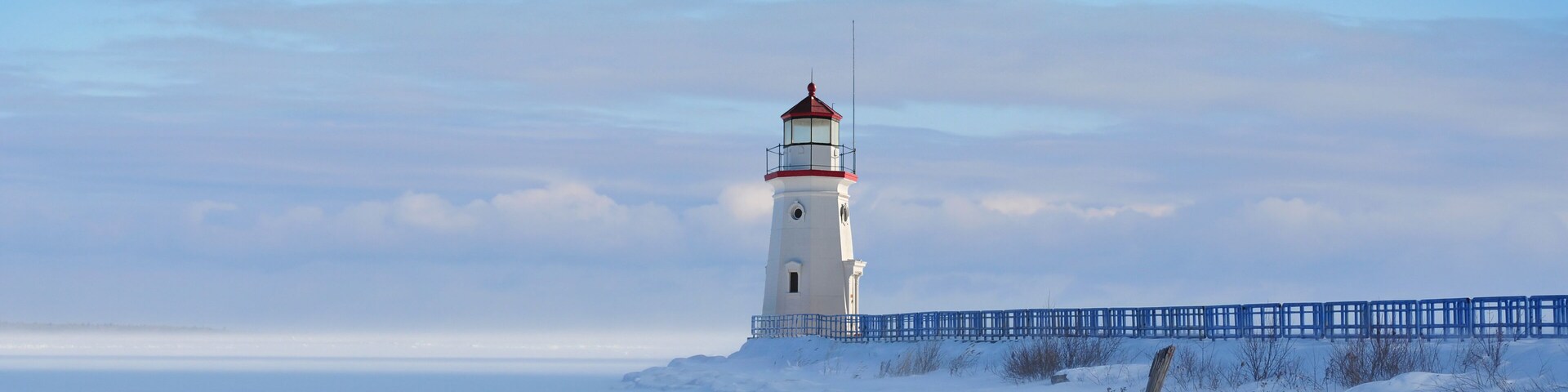 Lighthouse in a calm and desolate winter landscape.