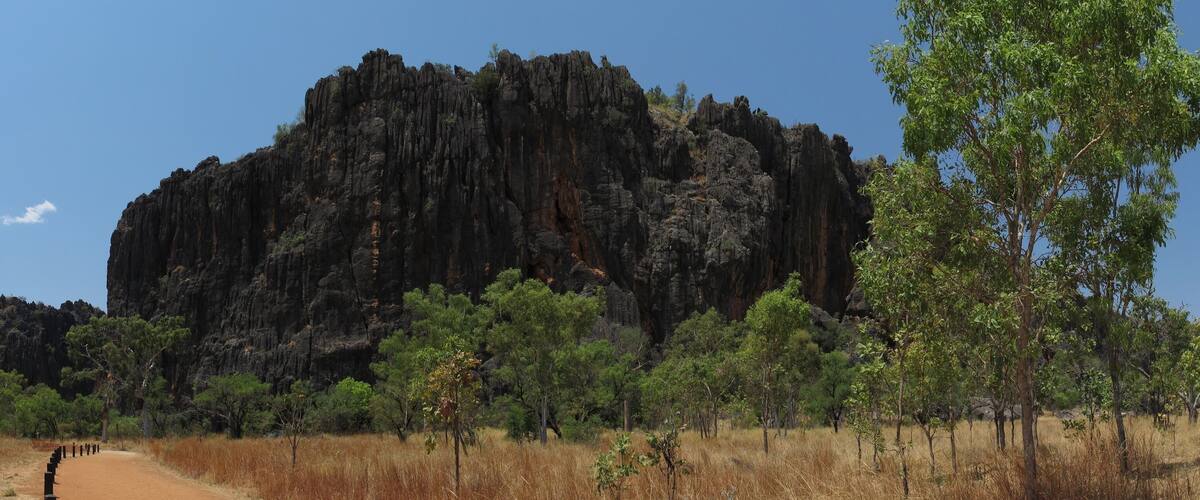 A large rocky mountain with sparse vegetation in the foreground.