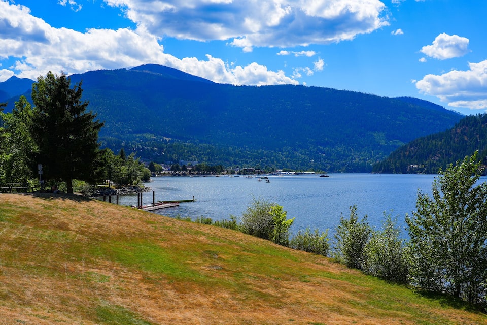 A lake surrounded by mountains, a dock, and a picnic area.