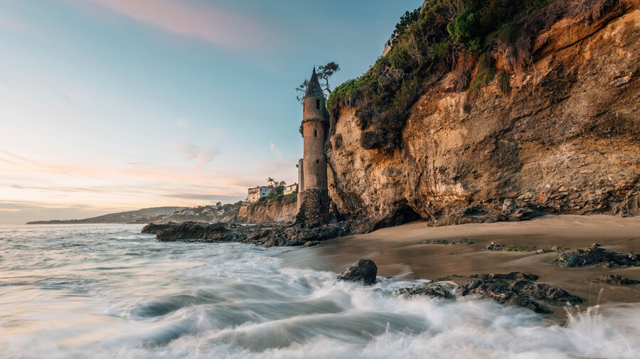 Waves in the Pacific Ocean and the Pirate Tower at sunset, at Victoria Beach, Laguna Beach, California