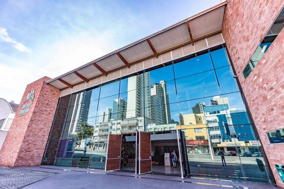 Een modern glazen gebouw met een gevel van baksteen en een ruime entree.