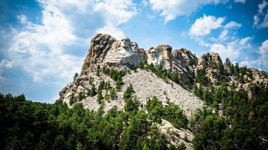 Mount Rushmore National Monument memorial in South Dakota with blue sky and cumulus clouds