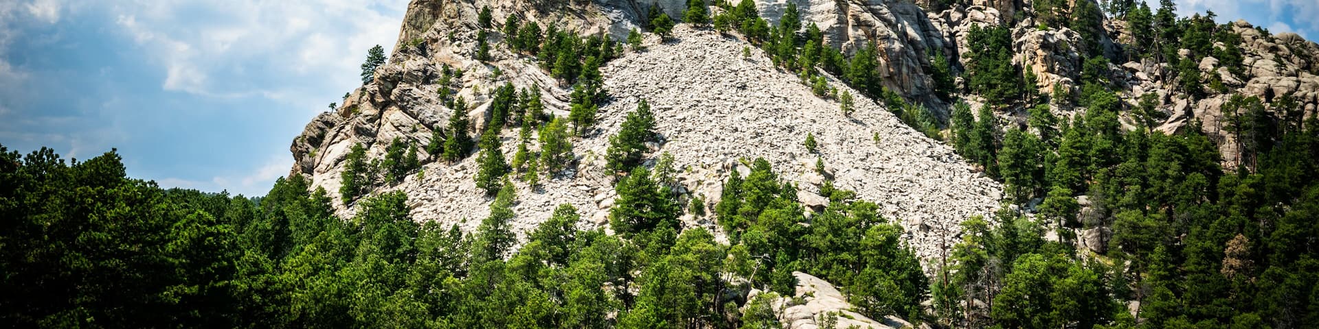 Mount Rushmore National Monument memorial in South Dakota with blue sky and cumulus clouds