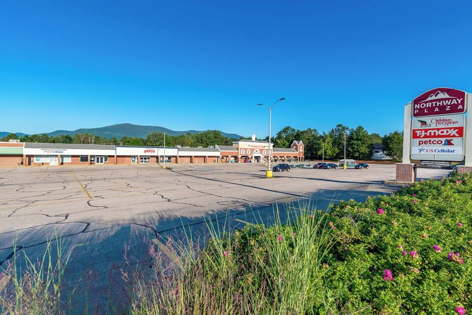 A parking lot with a sign for Northway Plaza, including stores like TJ Maxx and petco.