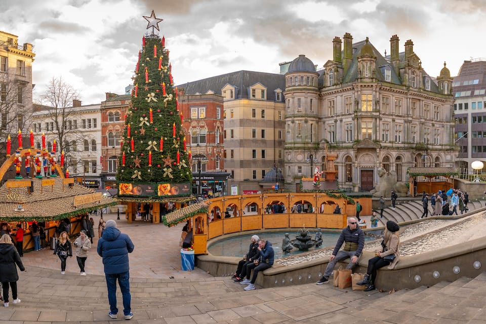 A festive Christmas market with a decorated Christmas tree and traditional stalls.